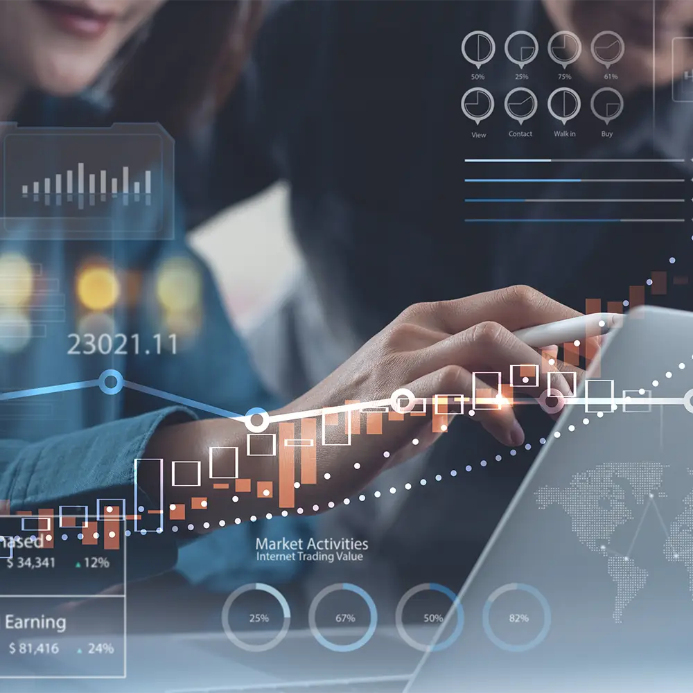 Stock market charts on a screen overlaying an investment management professional working on a client’s long-term portfolio growth.