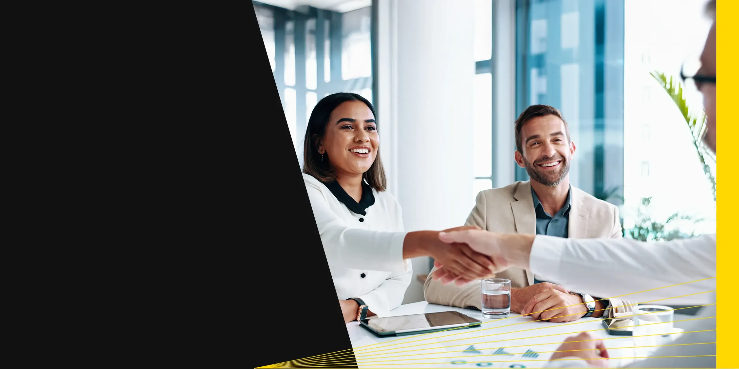 Wealth management advisor shaking hands with his clients, at an office in San Diego.