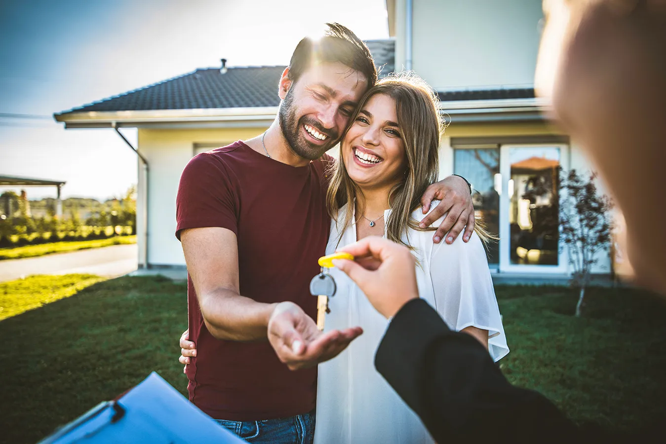 Ethnically ambiguous young couple receiving house keys.