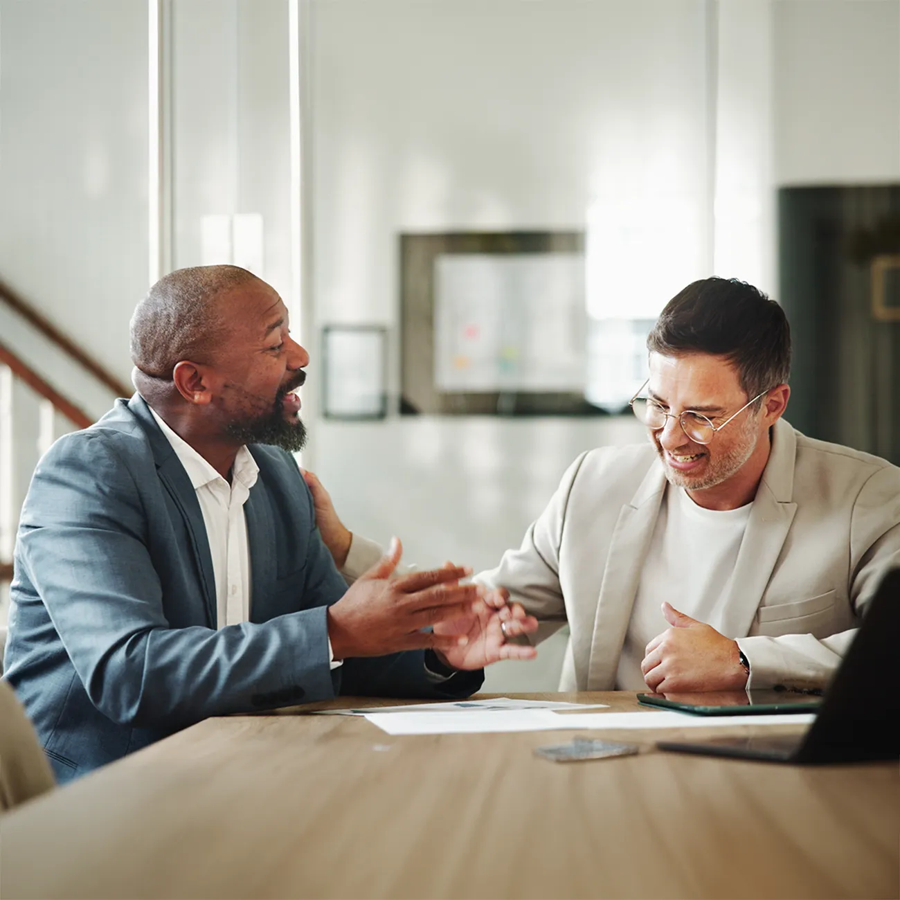 A financial advisor meeting with his Black male client to offer personalized wealth management in San Diego.