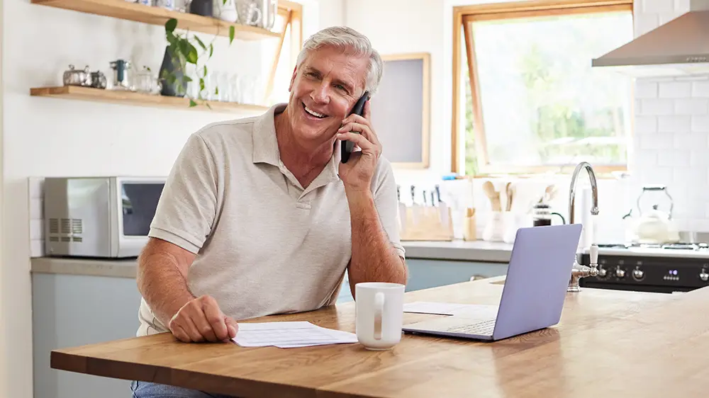 Caucasian senior man making a call at home.