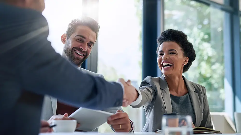 Handshake close-up with a financial advisor and his clients.